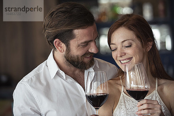 Lächelndes Paar hält Weinglas