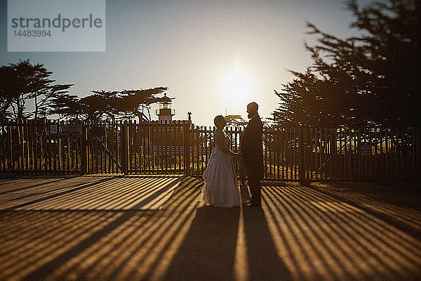Braut und Bräutigam stehen vor dem sonnigen Leuchtturm  Monterey  Lucas Point  Kalifornien  USA