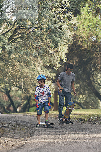 Brüder skateboarden im Park