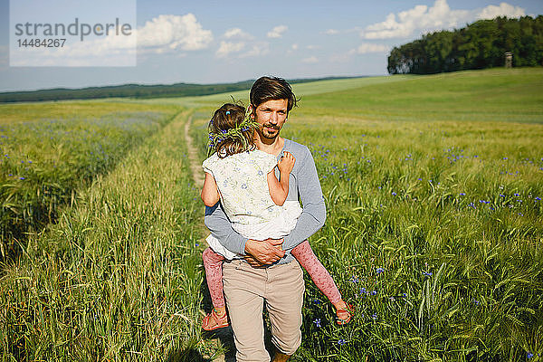 Porträt Vater mit Tochter in einem sonnigen  idyllischen ländlichen Feld