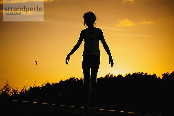 Silhouette Frau stehend gegen Sonnenuntergang Himmel