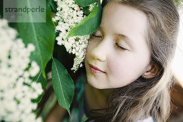 Gelassenes Mädchen lehnt an einer Blume