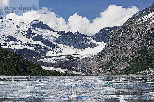 Zwei Kajakfahrer gleiten durch schwimmendes Eis vor dem Ogive Glacier  Northwestern Fjord des Kenai Fjords National Park  Kenai Peninsula  Southcentral Alaska