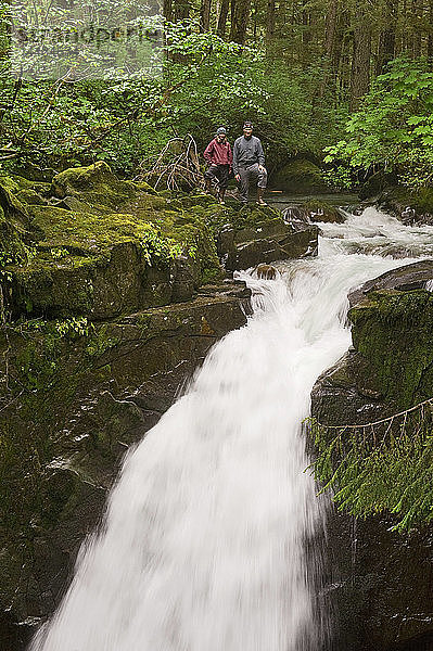 Zwei Wanderer stehen an der Spitze der Sawmill Creek Falls im Tongass National Rainforest in der Nähe von Juneau  Südost-Alaska