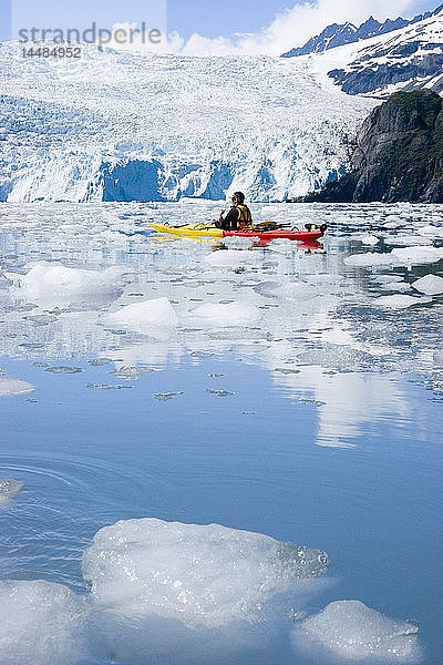 Kajakfahrer paddelt durch kleine Eisbrocken vor dem Aialik Glacier Kenai Fjords National Park Alaska Kenai Peninsula Sommer