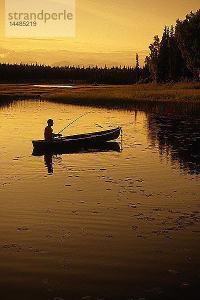 Mann fischt vom Kanu aus im See SC AK Sommer-Sonnenuntergang