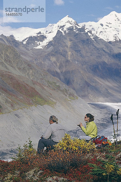 Rucksacktouristen machen eine Pause vom Klettern während einer Herbsttour im Wrangell-St.Elias National Pakr in Süd-Zentral-Alaska.