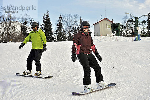 Pärchen beim Snowboarden im Hilltop-Skigebiet in Anchorage  Alaska