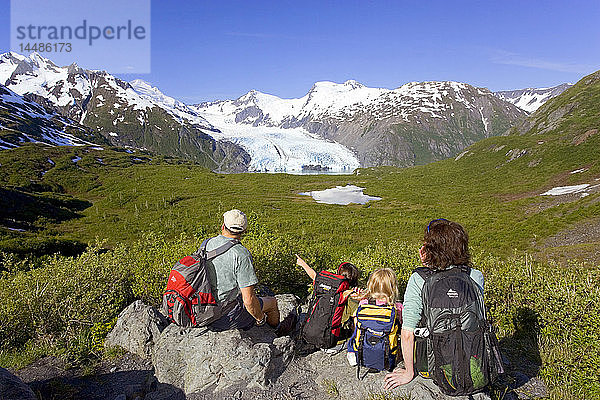 Familie sitzt auf einem Felsen mit Blick auf den Portage Gletscher vom Portage Pass Trail Chugach Mtns Alaska Sommer