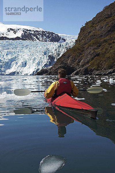 Mann fährt Kajak auf der Eisscholle des Aialik-Gletschers KP AK Spring Kenai Fjords NP