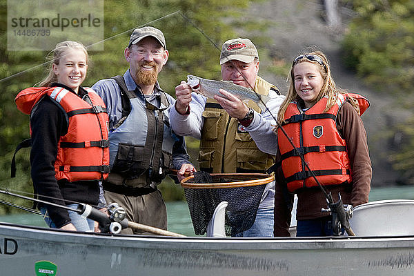 Familie und Reiseführer zeigen Regenbogenforellen  die vom Treibboot auf dem Kenai River auf der Kenai-Halbinsel in Alaska gefangen wurden