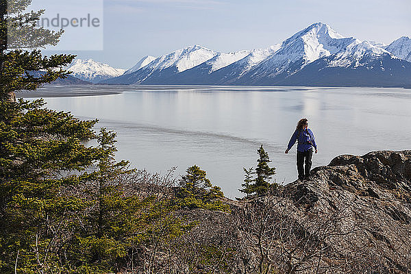 Frau bei einer Tageswanderung auf einem Bergrücken mit Blick auf den Turnagain Arm entlang des Seward Highway  Southcentral Alaska  Frühling