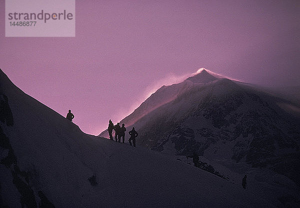 Bergsteiger stehen auf Kammlinie bei Sonnenuntergang Denali NP AK/nMt McKinley Hintergrund