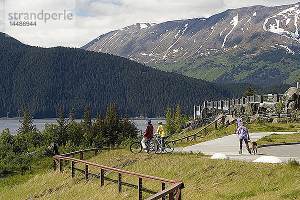 Junges Paar Fahrräder auf Pfad @ Bird Pt Rest Stop AK SC Turnagain Arm Chugach Mtns Sommer