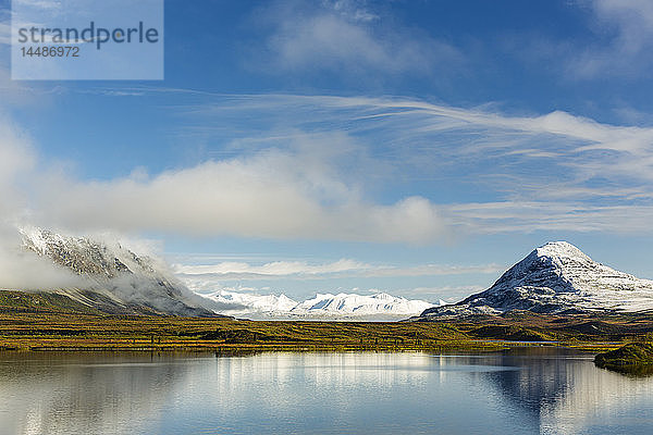 Die Amphitheater Mountains und die Alaska Range spiegeln sich im ruhigen Wasser des Round Tangle Lake in der Region Tangle Lakes am Denali Highway in Süd-Zentral-Alaska.