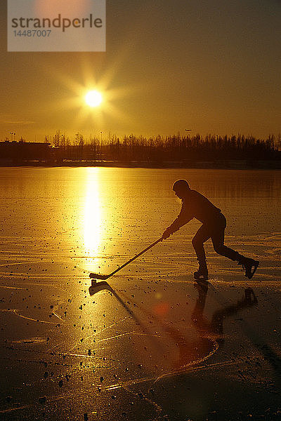 Person spielt Hockey Lake Hood Anchorage SC AK Winterlandschaft