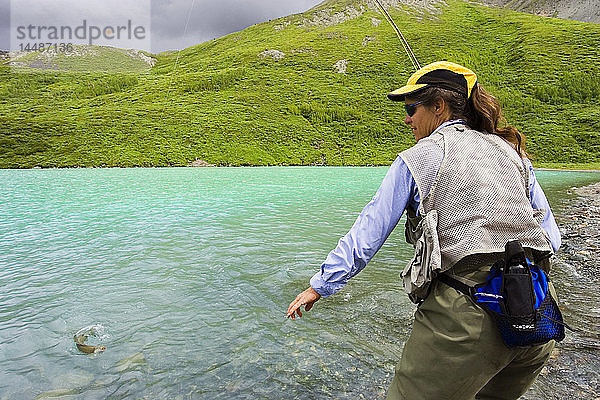 Frau beim Fliegenfischen auf arktische Äschen vom Ufer aus Turquoise Lake Lake Clark National Park Alaska Sommer