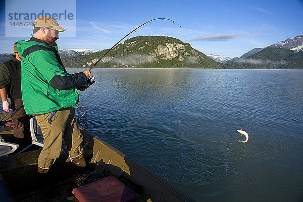 Ein Spinnfischer fängt einen Felchen  während er in einem Boot in den Big River Lakes in der Redoubt Bay State Critical Habitat Area in Süd-Zentral-Alaska steht  im Sommer