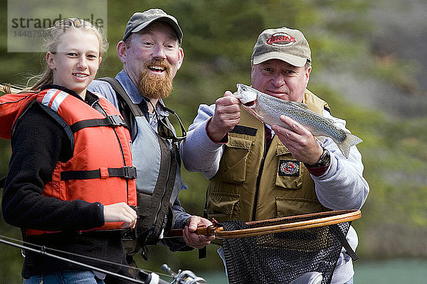 Familie und Reiseführer zeigen Regenbogenforellen  die vom Treibboot auf dem Kenai River auf der Kenai-Halbinsel in Alaska gefangen wurden