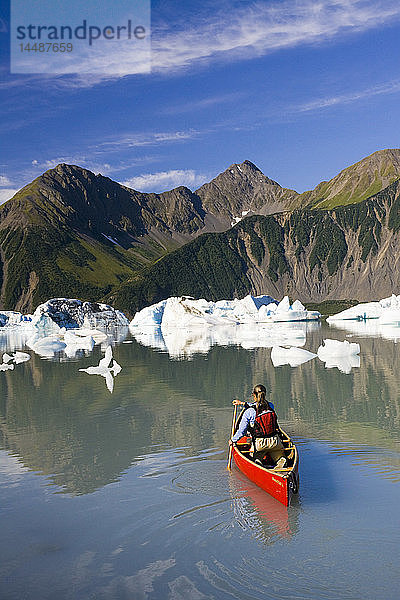 Eine Kanufahrerin paddelt zwischen den Eisbergen im Bear Glacier Lake in der Nähe des Bear Glacier  Kenai Fjords National Park  Kenai Peninsula  Southcentral Alaska  Sommer