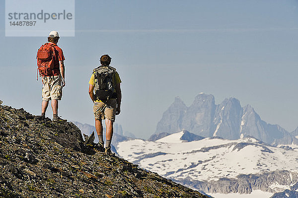 Zwei Wanderer genießen die Aussicht auf die Teufelskralle und das Juneau-Eisfeld vom Bergrücken des Mt. Juneau in der Nähe von Juneau im Südosten Alaskas