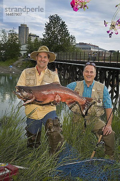 Fischer posiert mit Königslachs am Ship Creek in der Innenstadt von Anchorage  Alaska im Sommer