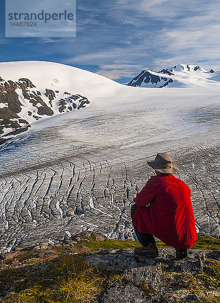Ein Mann blickt auf den Exit Glacier und das Harding Ice Feild im Kenai Fjords National Park auf der Kenai Penninsula in Süd-Zentral-Alaska