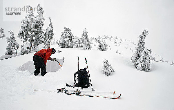 Ein Skifahrer gräbt eine Schneegrube  um den Zustand der Schneedecke zu testen  Juneau  Alaska