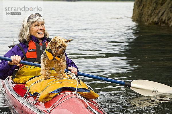 Ältere Seekajakfahrerin mit Shih-Tzu-Hund als Passagier in der Halibut Cove  Alaska