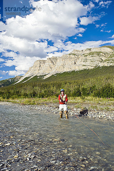 Mann beim Fliegenfischen auf dem Dietrich River in der Brooks Range im Sommer in Alaska