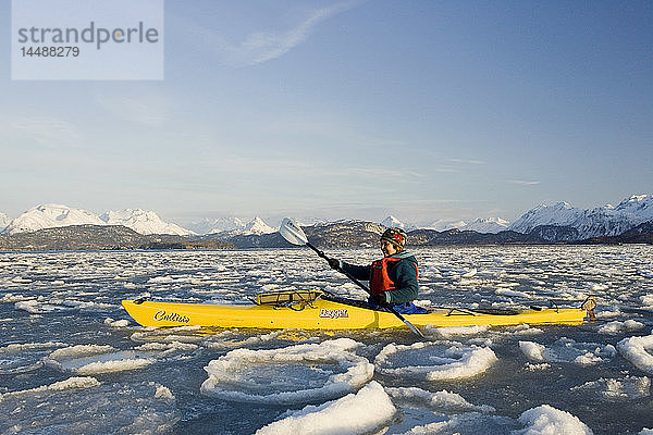 Frauen beim Seekajakfahren in der Eisscholle der Kachemak Bay in der Nähe von Homer Kenai Peninsula Alaska Winter