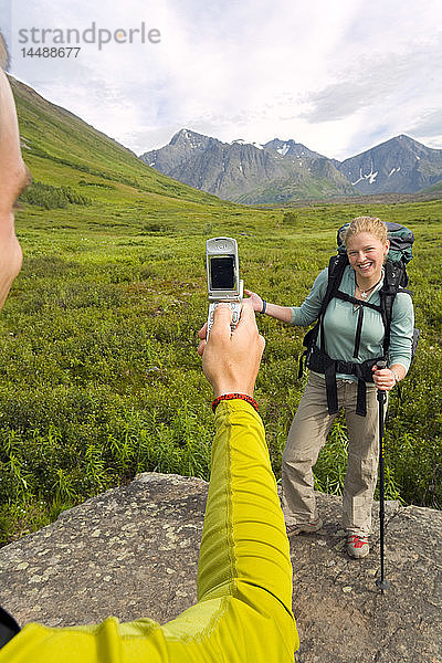 Wanderer fotografiert mit dem Handy einen Freund auf dem South Fork Eagle River Trail im Chugach State Park Alaska Sommer