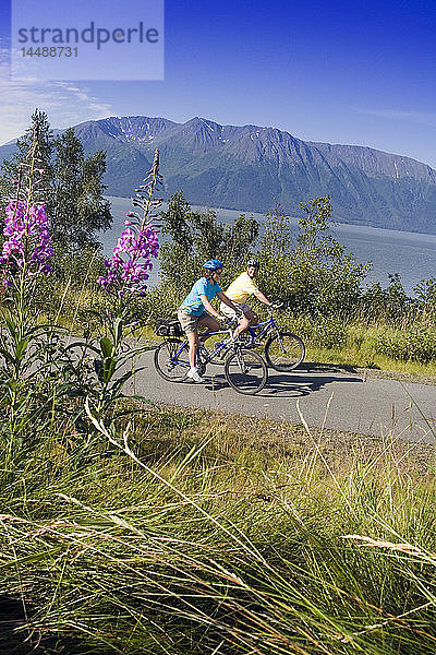 Ein Paar fährt zusammen Fahrrad auf dem Küstenpfad in der Nähe von Indian Alaska Turnagain Arm  SC Sommer.