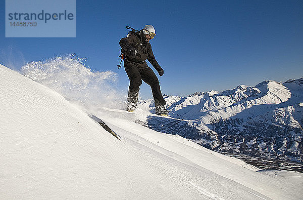 Ein Backcountry-Snowboarder schnappt beim Fahren am Hatcher Pass  Southcentral  Alaska  etwas Luft