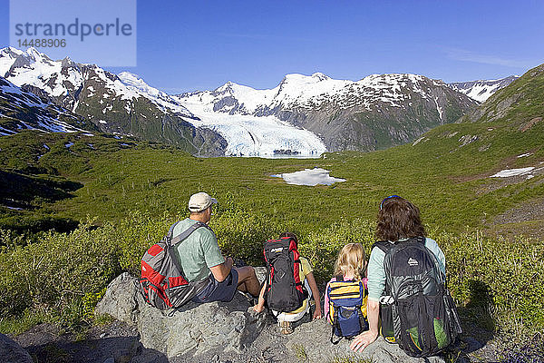 Familie sitzt auf einem Felsen mit Blick auf den Portage Gletscher vom Portage Pass Trail Chugach Mtns Alaska Sommer