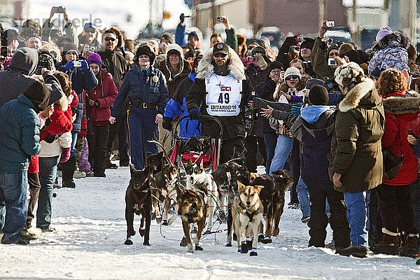 Lance Mackey läuft durch die Menschenmenge auf der Front Street in Nome zur Ziellinie als Sieger des Iditarod-Schlittenhunderennens 2010  Arctic Alaska