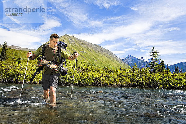 Männlicher Wanderer im Chugach State Park bei der Überquerung des South Fork of Eagle River unter Anwendung der richtigen Umgehungstechniken Alaska