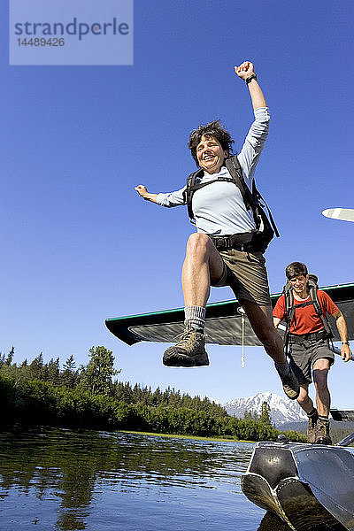 Menschen springen vom Wasserflugzeug zum Ufer des Sees  um zu wandern Kenai Mtns Kenai Peninsula Alaska Sommer
