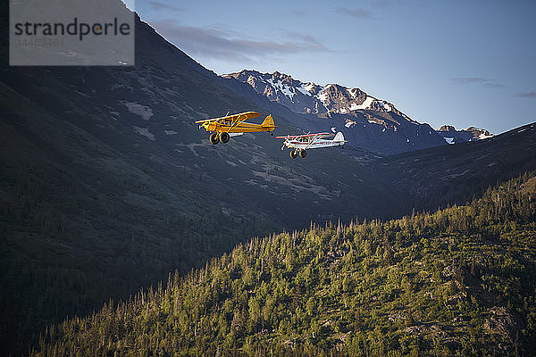 Super-Cub-Flugzeuge fliegen über das Turnagain-Arm-Gebiet mit den Chugach Mountains im Hintergrund  Süd-Zentral-Alaska