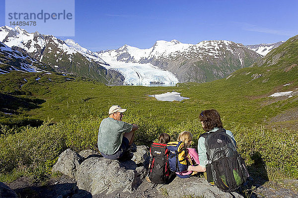 Familie sitzt auf einem Felsen mit Blick auf den Portage Gletscher vom Portage Pass Trail Chugach Mtns Alaska Sommer