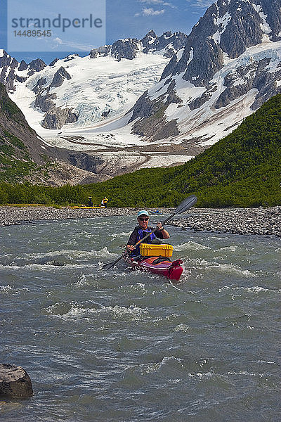 Eine Kajakfahrerin manövriert einen Fluss im Northwestern Fjord des Kenai Fjords National Park hinunter  Kenai Halbinsel  Süd-Zentral-Alaska  Sommer