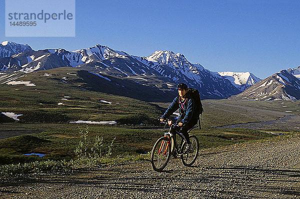 Frau auf dem Fahrrad auf der Denali National Park Road im Inneren Alaskas Frühling