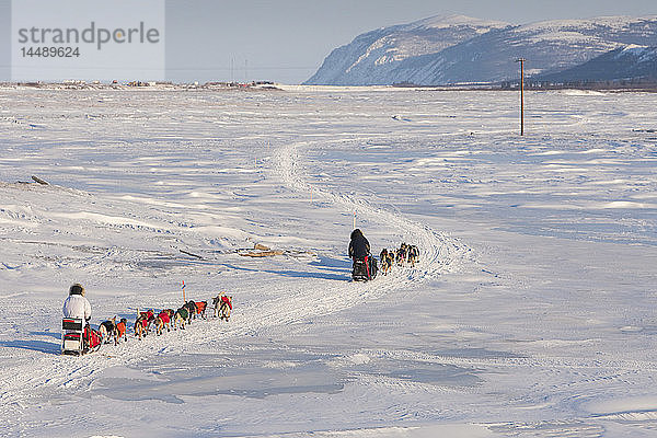 Bruce Linton läuft vor Paul Gebhart auf dem Unalakleet-Slough-Eis  nachdem er Unalakleet im arktischen Alaska während des Iditarod 2010 verlassen hat.