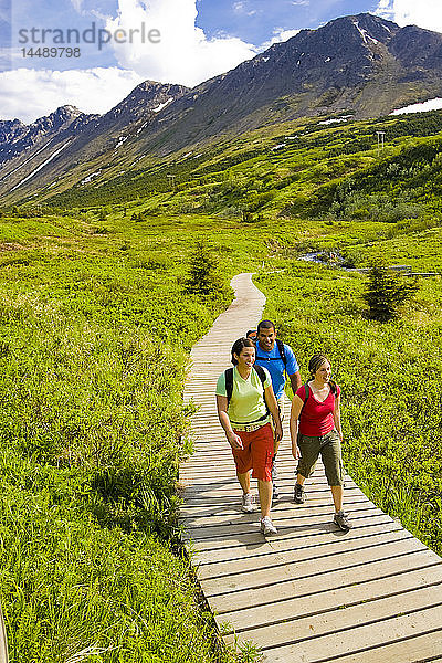 Familienwanderung auf dem Holzsteg des Middle Fork Loop Trail im Gebiet der Glen Alps im Chugach State Park  Süd-Zentral-Alaska