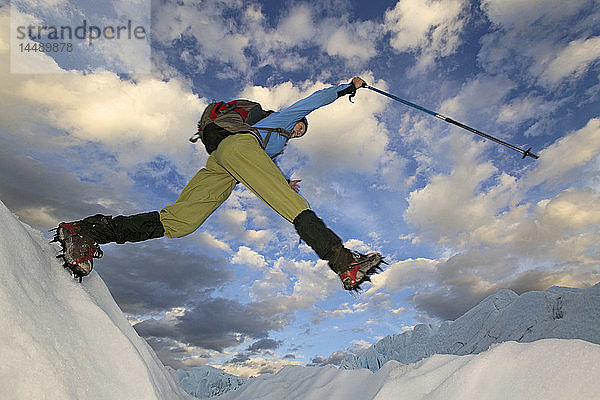 Wanderer springt über die Gletscherspalte Matanuska Glacier SC AK Sommer