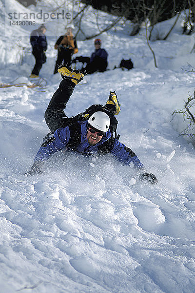 Mann rutscht nach Besteigung des Keystone Canyon SC AK Winter den Abhang hinunter