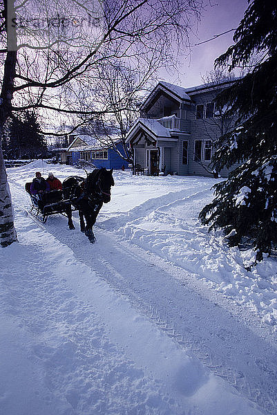 Menschen auf Schlittenfahrt vor dem Haus Anchorage AK