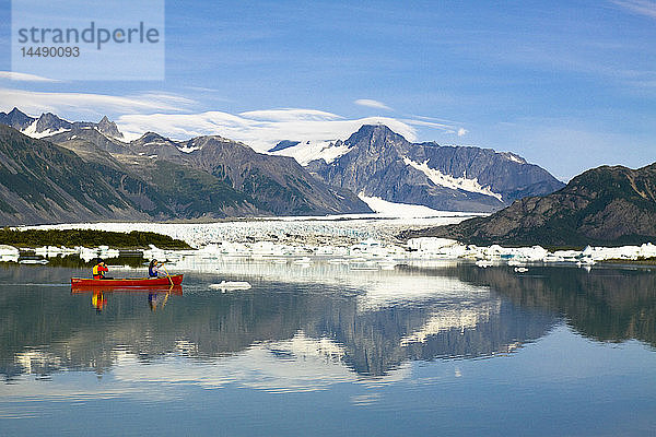 Kanufahrerin paddelt zwischen den Eisbergen im Bear Glacier Lake mit dem Bear Glacier im Hintergrund  Kenai Fjords National Park  Kenai Peninsula  Southcentral Alaska  Sommer