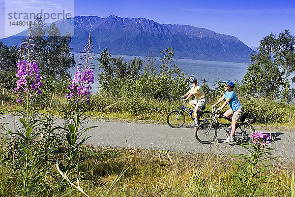 Ein Paar fährt zusammen Fahrrad auf dem Küstenweg in der Nähe von Indian Alaska Turnagain Arm  SC Sommer.