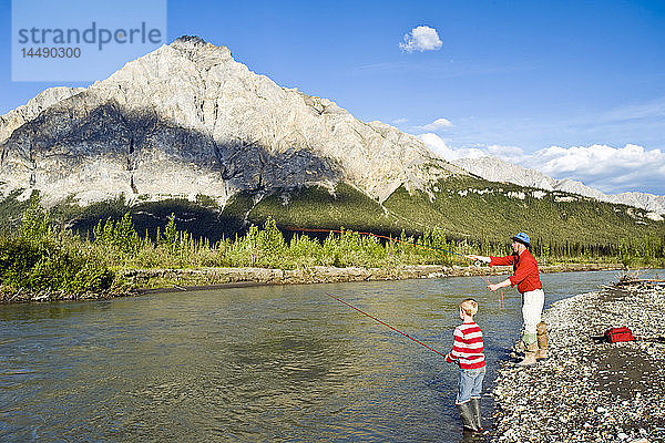 Vater und Sohn beim Angeln auf dem Koyukuk River in der Brooks Range im Sommer in Alaska